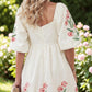 Beige floral print puff-sleeve babydoll dress with pink embroidered flowers, back view.