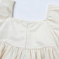 Beige floral-print puff-sleeve babydoll dress bodice with gathered waist.