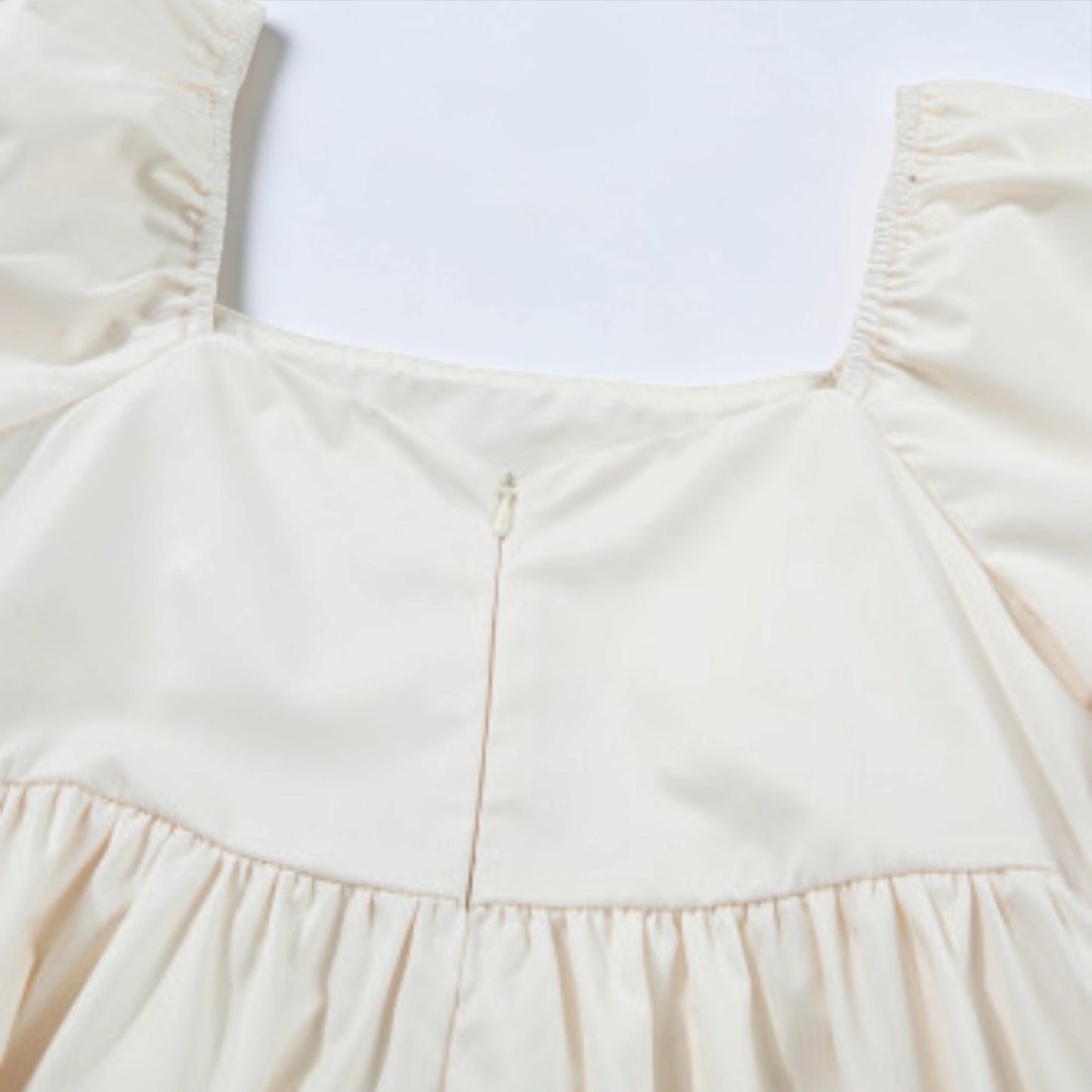 Beige floral-print puff-sleeve babydoll dress bodice with gathered waist.