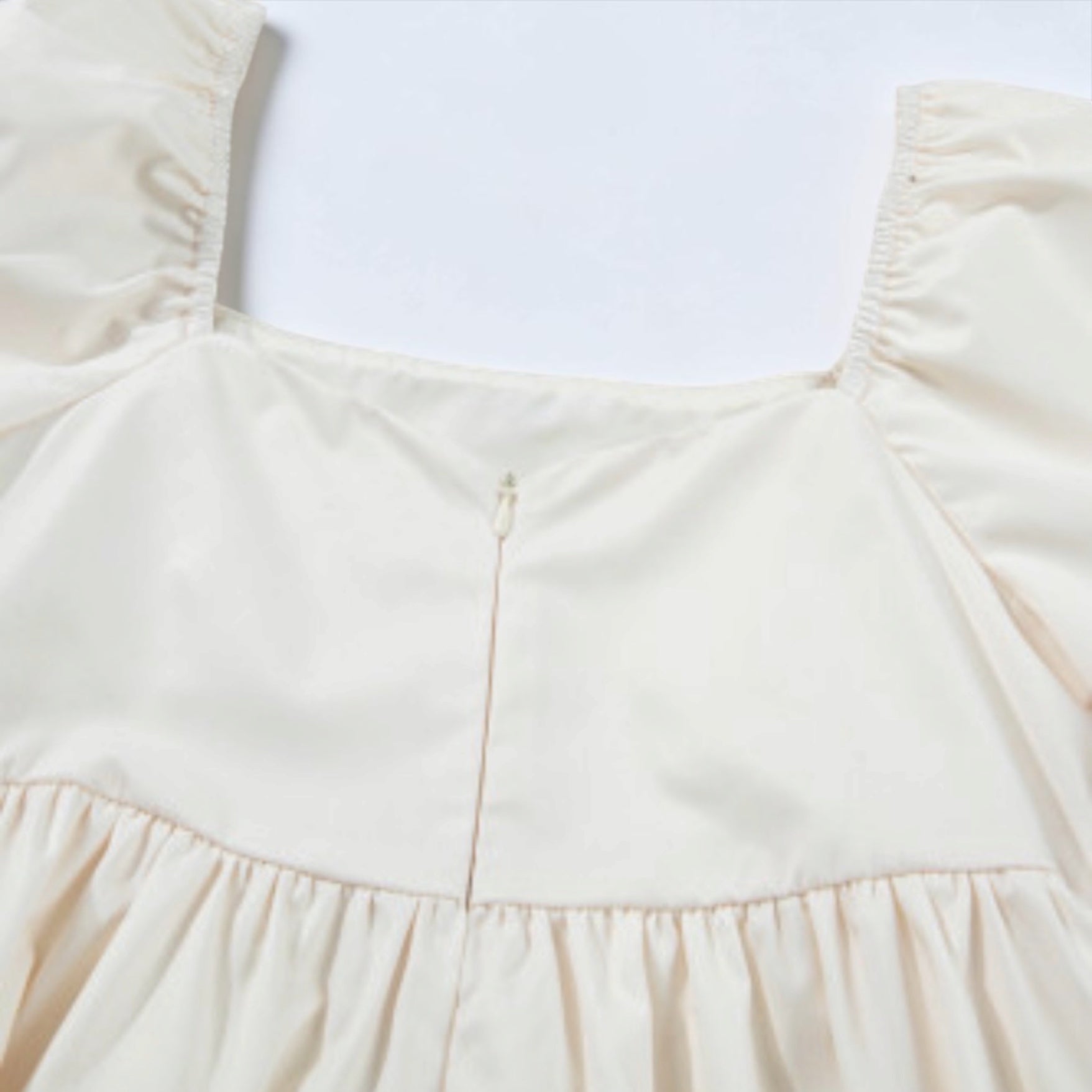 Beige floral-print puff-sleeve babydoll dress bodice with gathered waist.