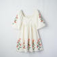 Beige floral-print puff sleeve babydoll dress with pink flowers along sleeves and hem.