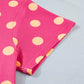 Pink twisted ribbed top with peach polka dots and a patch pocket.