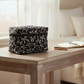 Black and white Coquette Bows quilted cosmetic bag on a wooden table.
