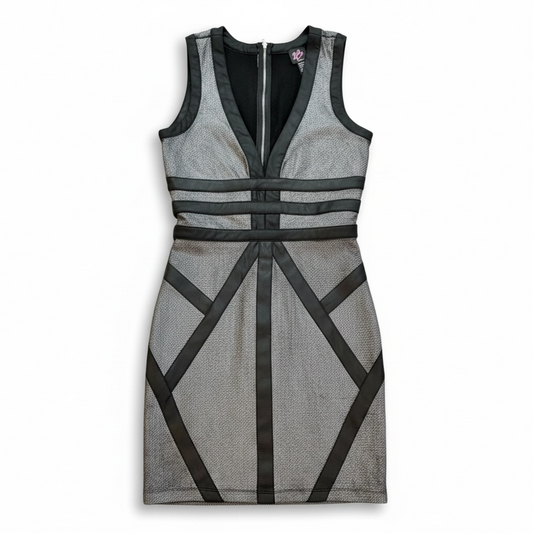 B2 Bebe black sleeveless cocktail dress with silver shimmer contrast and geometric satin panels, knee-length.